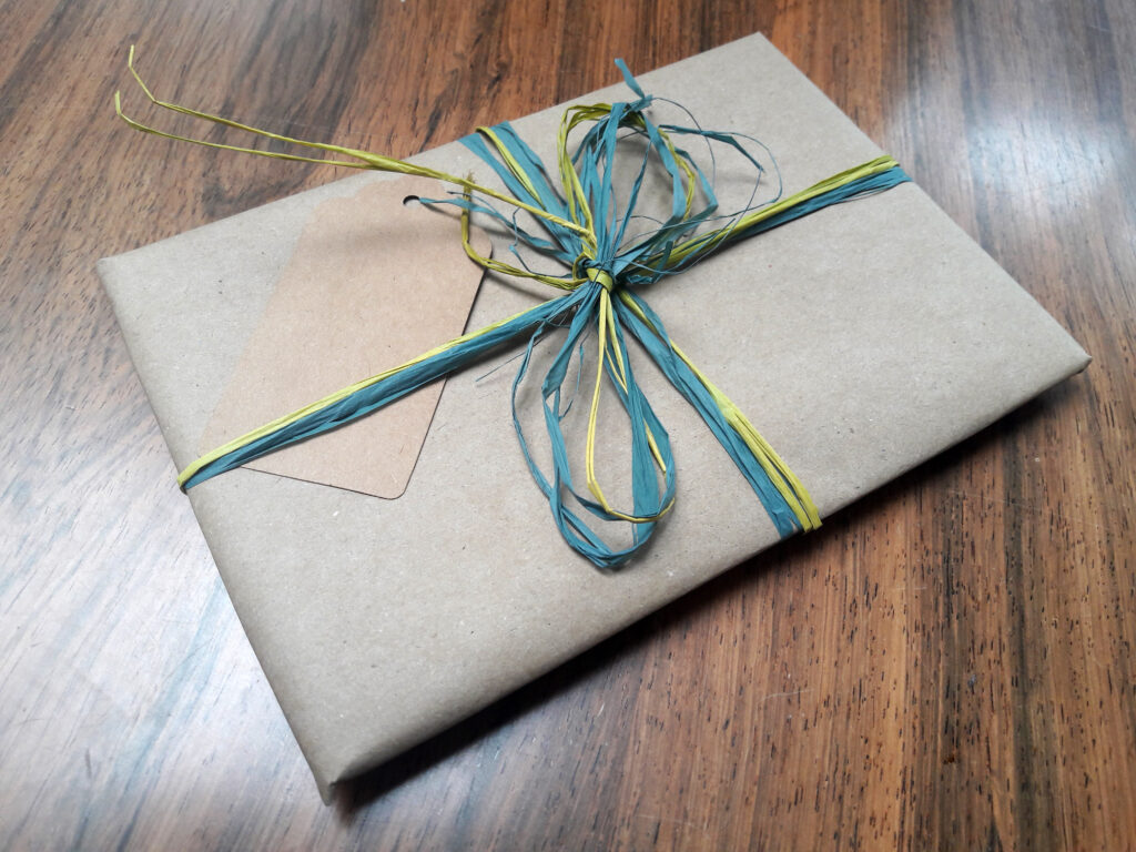 Wrapped in natural Kraft paper and tied up with coloured raffia. Your message will be hand-written on a natural Kraft gift tag